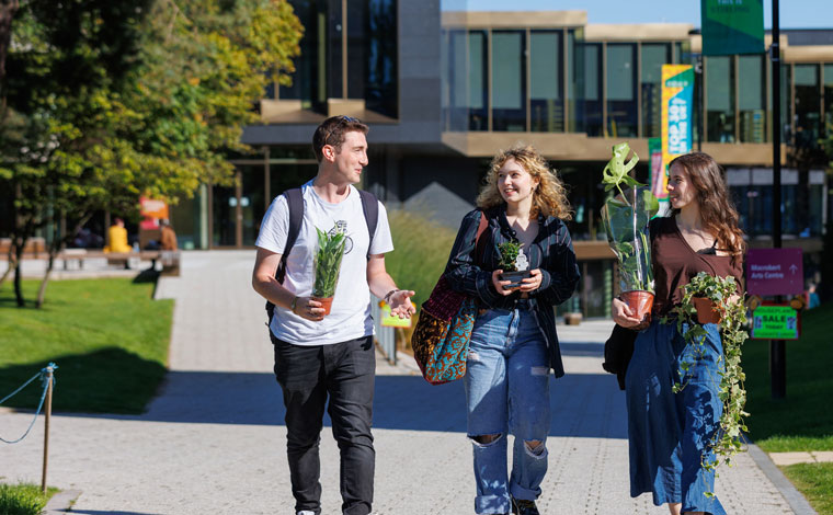 A group of students walking through the lush campus