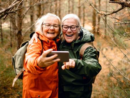 two elderly women taking selfie in woods