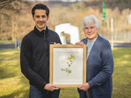 An image of Janet Watson and Dr Mario Vallejo-Marin holding a picture of the Shetland Monkeyflower 