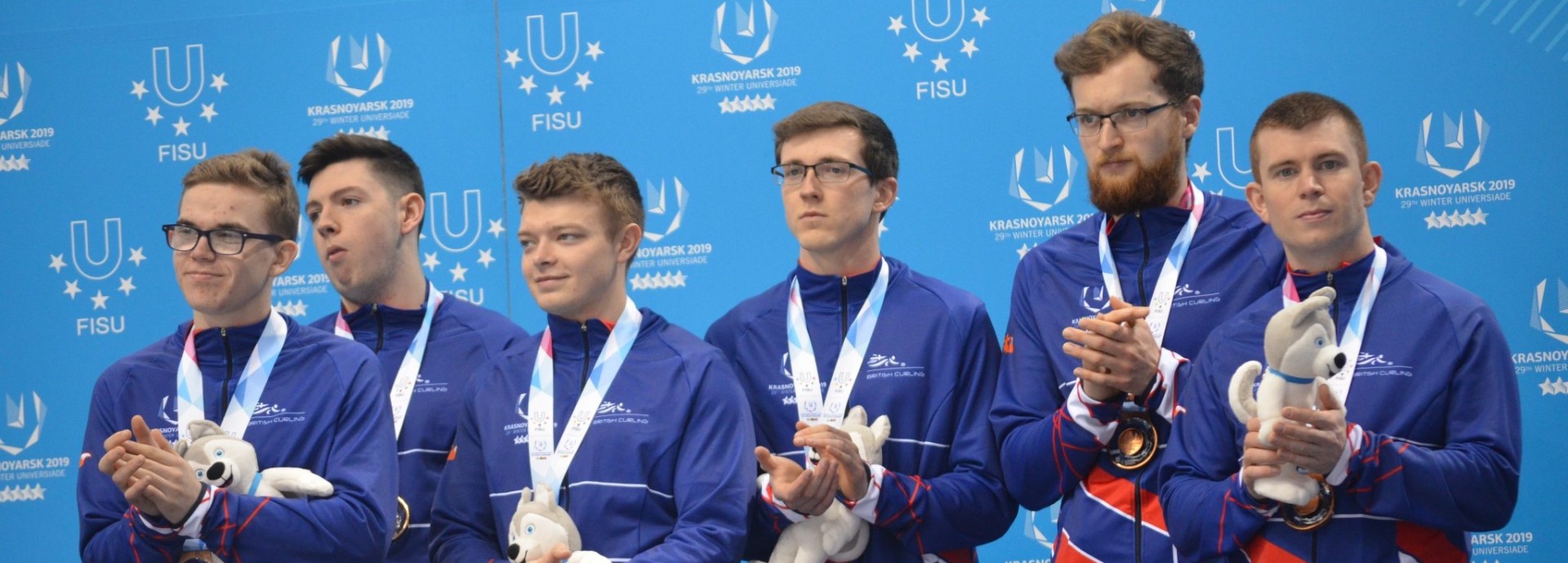 Ross Whyte with curling teammates on podium at World University Winter Games