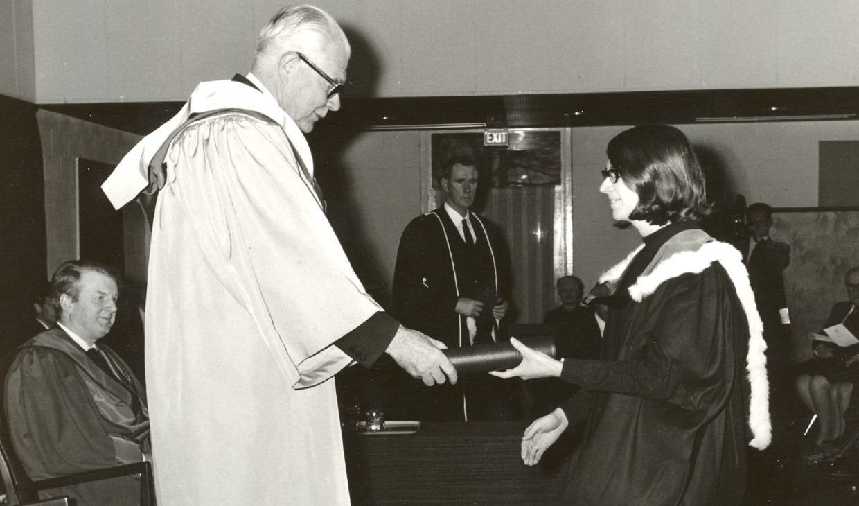 Lord Robbins conferring the first Master’s Degree of the University to Hazel Sommerville (nee Cairns) at the inaugural graduation ceremony, Pathfoot Dining Hall, December 1968_1920x730
