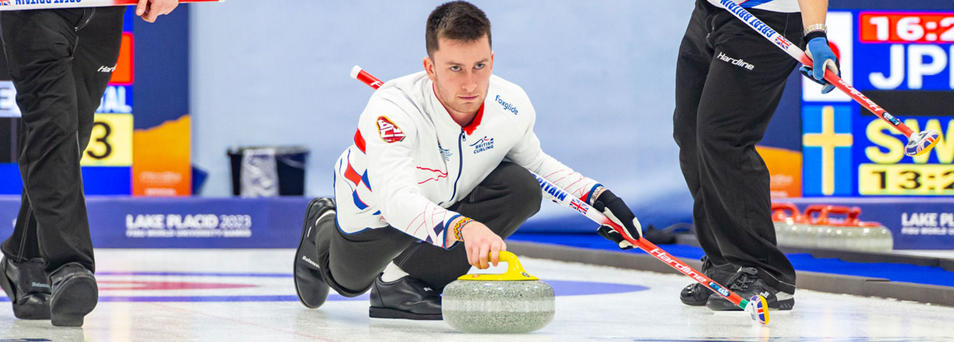 James Craik slides a stone down the sheet during the World University Games in Lake Placid.