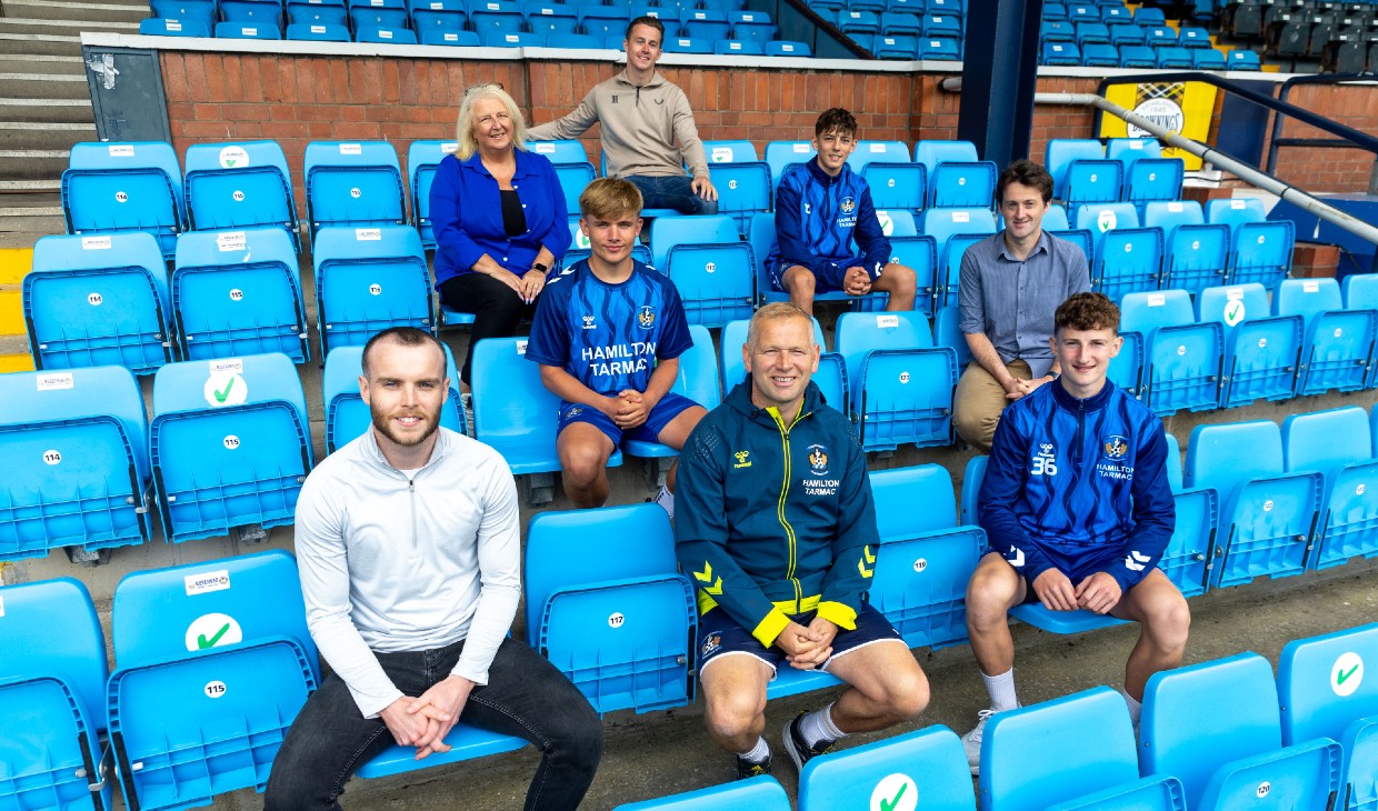 2.	From top, L to R: Wellbeing Coach Louis Kerr, Moira Greentree of Care Visions, Under-18s Kilmarnock players Josh and Logan, Allan Muirhead of Care Visions, Wellbeing Coach Louis Kerr and Kilmarnock Football Club’s Youth Ambassador, Charlie Adams., sitting in stands at Rugby Park