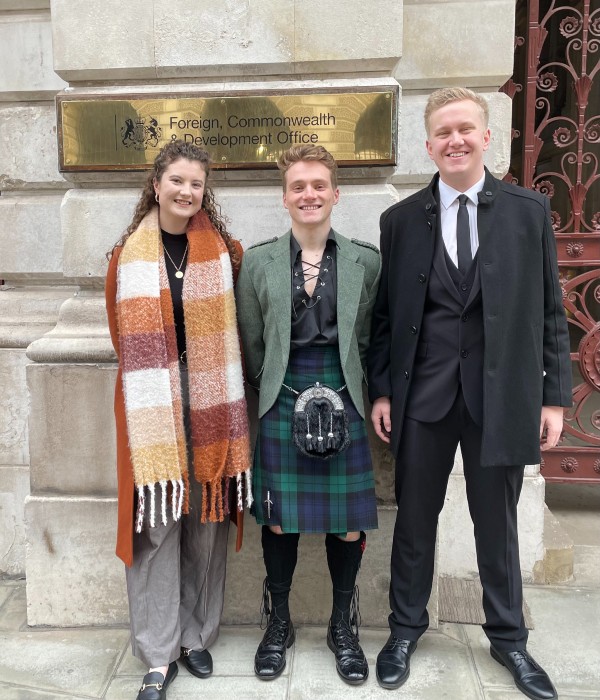 Jenna Carty, Jamie Robinson and Lauri Merilaeinen stand outside the offices of the Foreign Foreign, Development and Commonwealth Office, London.