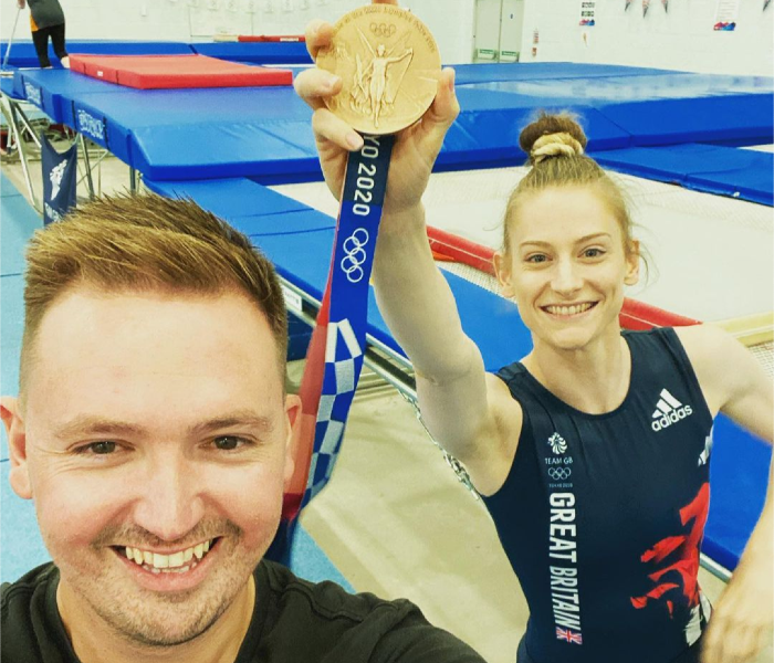 Coach Paul Greaves with Olympian Bryony Page, who holds aloft her medal, in a trampoline centre