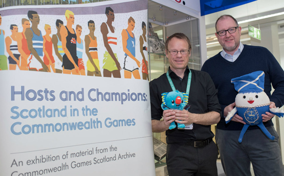 Research staff beside Commonwealth Games banner